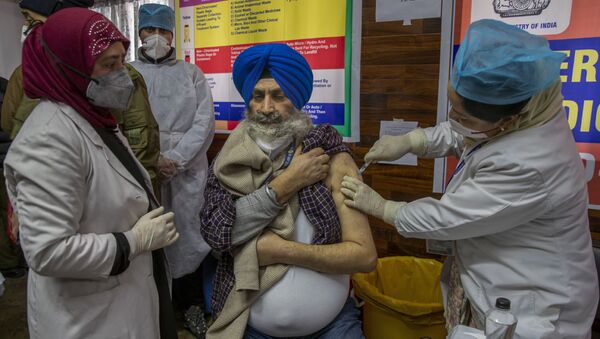 Em Srinagar, na Índia, um profissional de saúde é vacinado contra a COVID-19 no início da campanha de vacinação contra a doença no país, em 16 de janeiro de 2020 - Sputnik Brasil