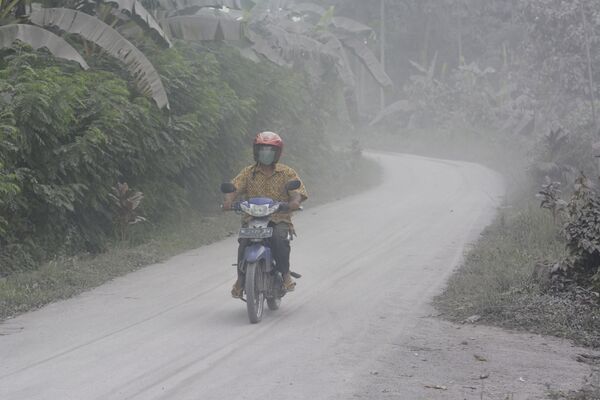 Motociclista passa por estrada coberta de cinzas vulcânicas da erupção do Monte Semeru, na ilha de Java, Indonésia, em 17 de janeiro de 2021 - Sputnik Brasil