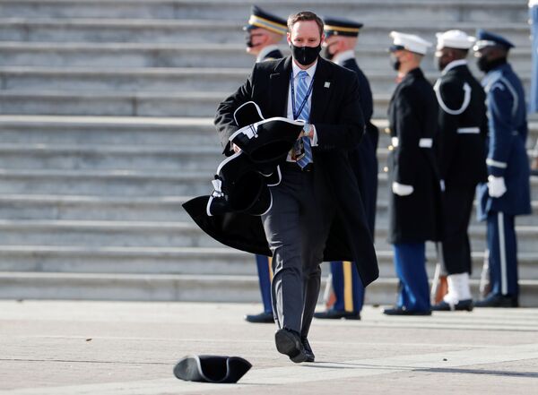 Funcionário junta chapéus após cerimônia de posse de Joe Biden como 46º presidente dos EUA, 20 de janeiro de 2021 - Sputnik Brasil