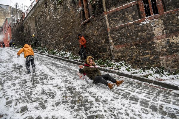 Crianças deslizam em rua coberta de neve, Istanbul, Turquia, 18 de janeiro de 2021 - Sputnik Brasil