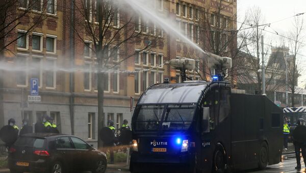 A polícia usa um canhão de água durante protesto contra as restrições impostas para conter a propagação da COVID-19, em Amsterdã, Países Baixos - Sputnik Brasil