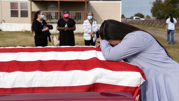 Pessoas em luto durante enterro de parente, falecido em função da COVID-19, em San Felipe, Texas, EUA, 26 de janeiro de 2021 - Sputnik Brasil
