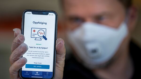Em Oslo, na Noruega, um homem mostra na tela de um celular um aplicativo de rastreamento de casos de COVID-19 do Instituto Nacional de Saúde Pública do país, em 16 de abril de 2020 - Sputnik Brasil