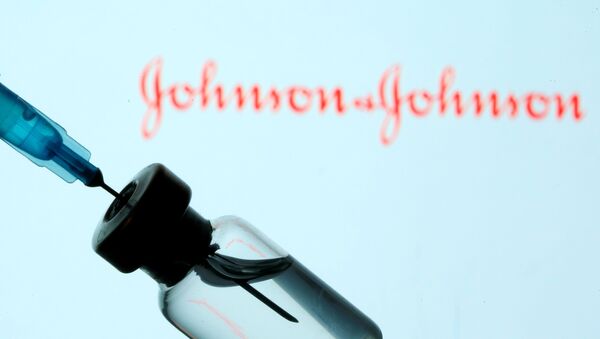 Um frasco e uma seringa são fotografados à frente do logotipo da Johnson & Johnson, no dia 11 de janeiro de 2021 - Sputnik Brasil
