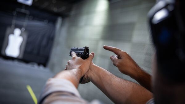 Homem aprende técnica de disparo de arma de fogo - Sputnik Brasil