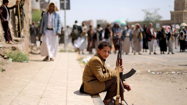 Garoto segura rifle durante ato do movimento houthi na capital do Iêmen, Sanaa, 30 de agosto de 2020 (foto de arquivo) - Sputnik Brasil