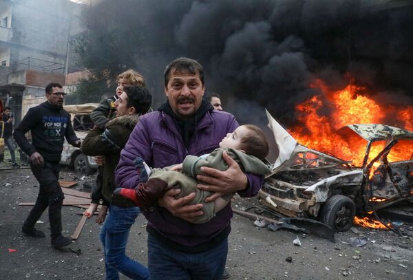 Homem leva criança ferida por explosão de um carro-bomba na cidade de Azaz, Síria, em 31 de janeiro de 2021 - Sputnik Brasil