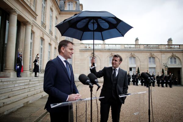 Presidente da França, Emmanuel Macron, carrega guarda-chuva ao lado do primeiro-ministro da Eslováquia, Igor Matovic, durante comunicação conjunta no Palácio do Elysée em Paris, França, 3 de fevereiro de 2021 - Sputnik Brasil