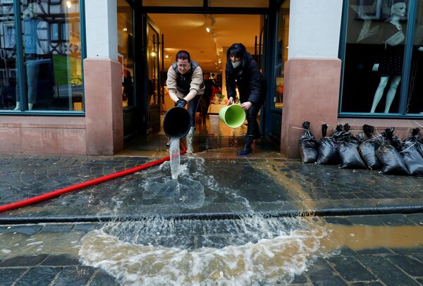 Empregadas de loja de roupa limpam consequências de inundação na cidade de Buedingen, Alemanha, 30 de janeiro de 2021 - Sputnik Brasil