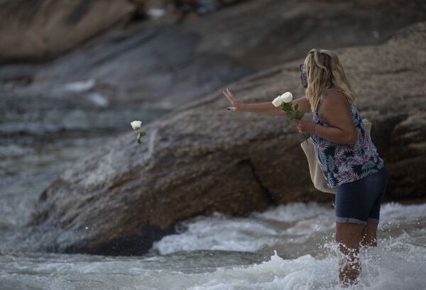 Mulher joga flores no oceano como oferenda à deusa do mar Iemanjá, no culto de matriz africana, na Praia Vermelha, Rio de Janeiro, 2 de fevereiro de 2021 - Sputnik Brasil