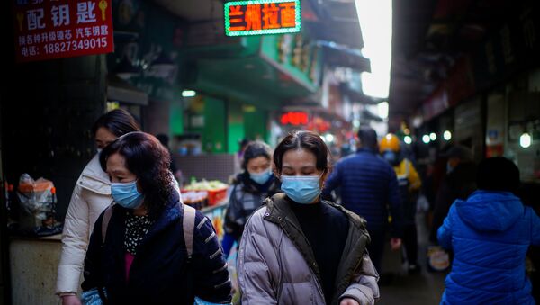 Pessoas usando máscaras de proteção em um mercado de rua durante o surto da COVID-19, Wuhan, China, 8 de fevereiro de 2021 - Sputnik Brasil