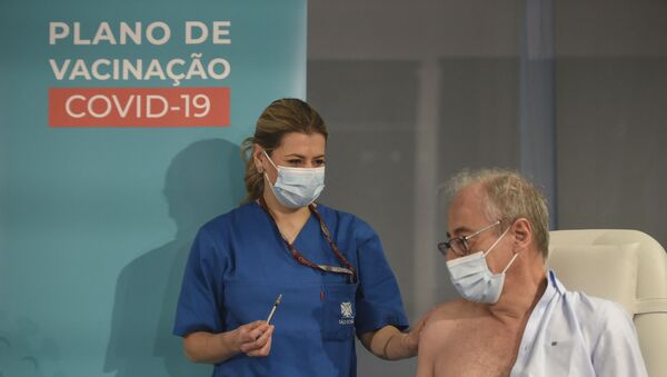 O médico António Sarmento recebe a primeira dose da vacina Pfizer-BioNTech contra a COVID-19 no Hospital São João, no Porto, em Portugal, em 27 de dezembro de 2020 - Sputnik Brasil