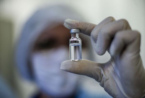 Funcionária mostra frasco da vacina da AstraZeneca contra COVID-19 produzida pela Fiocruz, Rio de Janeiro, 12 de fevereiro de 2021 - Sputnik Brasil