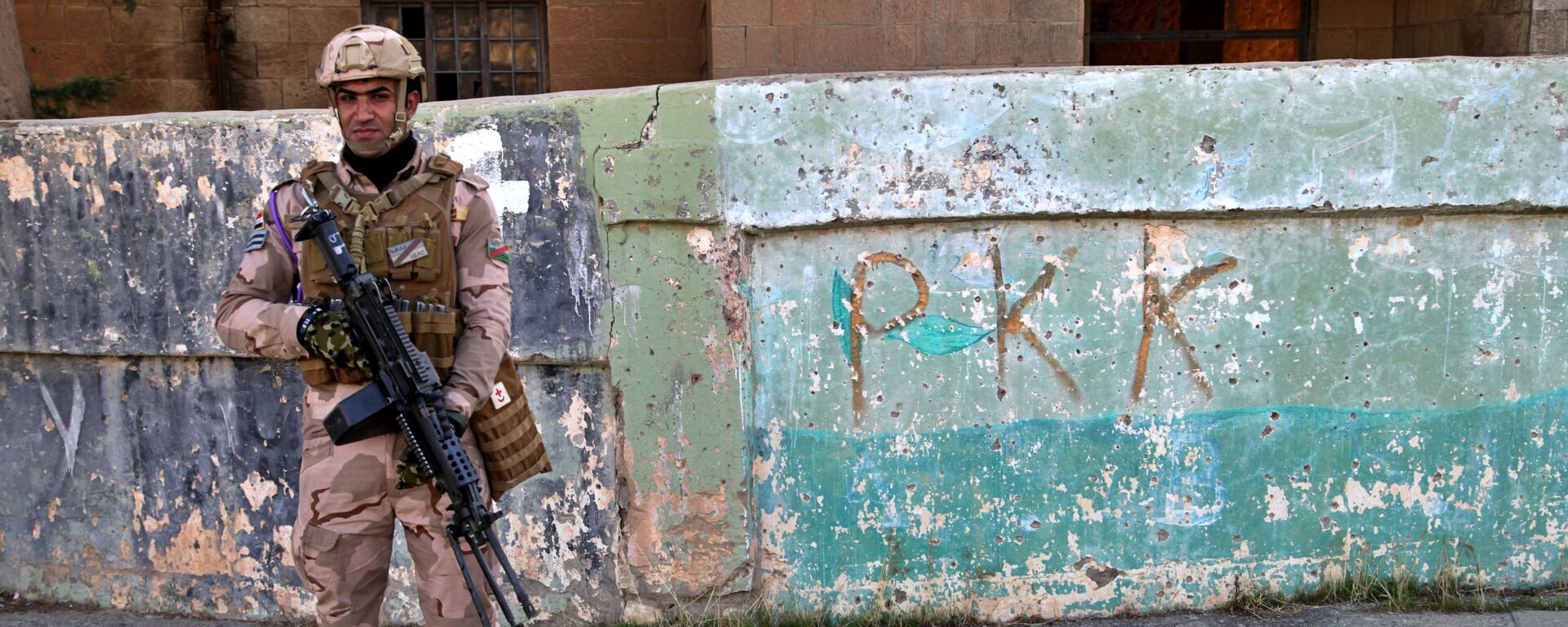 Soldado iraquiano em frente ao muro com inscrição PKK - Sputnik Brasil, 1920, 14.11.2022