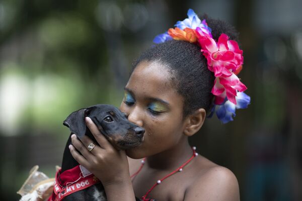 Sofia, de 11 anos de idade, beija seu cachorrinho durante o desfile de cachorros anual do Carnaval no Rio de Janeiro, Brasil, 13 de fevereiro de 2021 - Sputnik Brasil