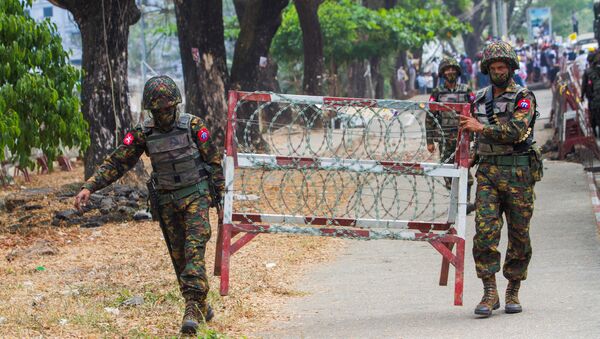 Militares carregam parte de cerca de arame farpado durante protesto contra tomada do poder por militares em Mianmar - Sputnik Brasil