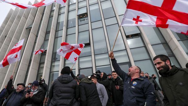 Opposition supporters wave flags following the announcement of Georgian Prime Minister Giorgi Gakharia's resignation outside the headquarters of the United National Movement (UNM) party in Tbilisi, Georgia February 18, 2021. - Sputnik Brasil