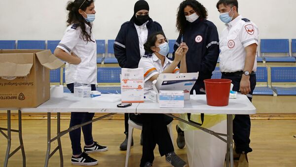 Medical personnel work at a temporary vaccination centre where vaccinations against the coronavirus disease (COVID-19) are administered, at a sports court in Tel Aviv, Israel February 16, 2021. - Sputnik Brasil