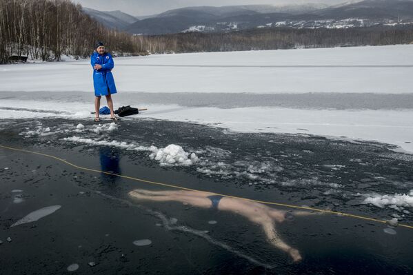 Homem perto do lago Barbora, República Tcheca, onde seu amigo, David Vencl, nada debaixo do gelo durante treinamento para bater o recorde Guinness de mergulho mais longo debaixo do gelo, 13 de fevereiro de 2021 - Sputnik Brasil