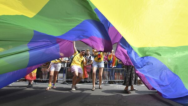 Manifestantes carregam bandeira LGBT em parada gay realizada em Londres, no Reino Unido - Sputnik Brasil