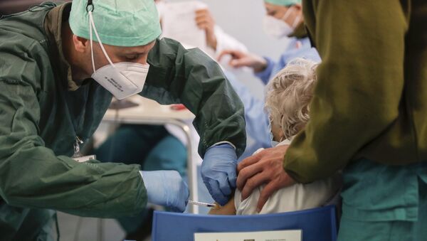 Em Milão, na Itália, um profissional de saúde aplica uma dose de uma vacina contra a COVID-19 em uma idosa, em 18 de fevereiro de 2021 - Sputnik Brasil