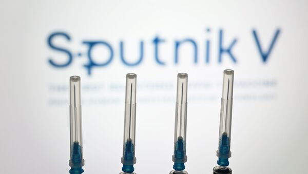 Seringas com o logotipo da Sputnik V ao fundo - Sputnik Brasil