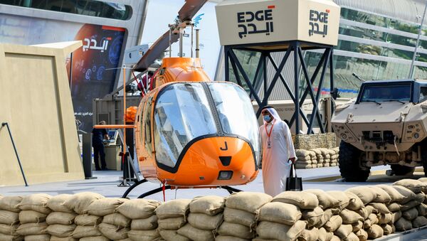 Homem perto de um helicóptero no estande do grupo tecnológico EDGE na exposição de defesa IDEX 2021 em Abu Dhabi, EAU, 22 de fevereiro de 2021. - Sputnik Brasil