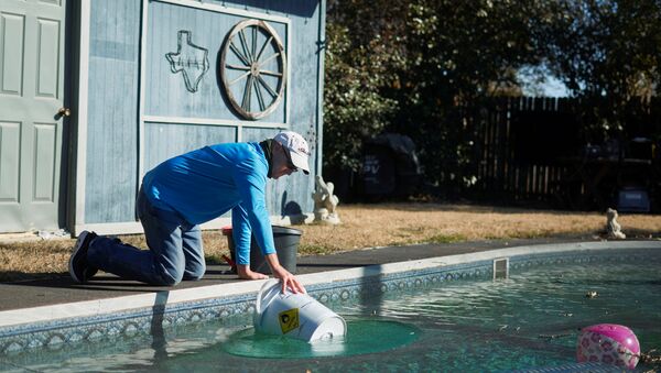 Morador do Texas coleta água de sua piscina, em meio à falta de água e energia no estado norte-americano do Texas, 20 de fevereiro de 2021 - Sputnik Brasil