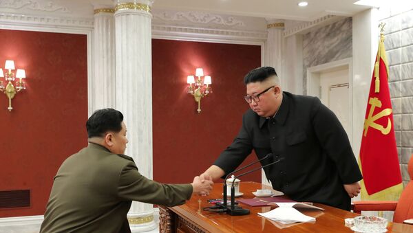 Líder norte-coreano, Kim Jong-un, cumprimenta servidor durante 8ª Reunião da Comissão Militar Central do país, em Pyongyang, Coreia do Norte, 24 de fevereiro de 2021 - Sputnik Brasil