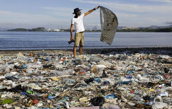 Fotógrafo e biólogo marinho Ricardo Gomes, membro do Instituto Mar Urbano, organização não governamental, pega lixo nas margens da Baía de Guanabara no Rio de Janeiro, 24 de fevereiro de 2021 - Sputnik Brasil