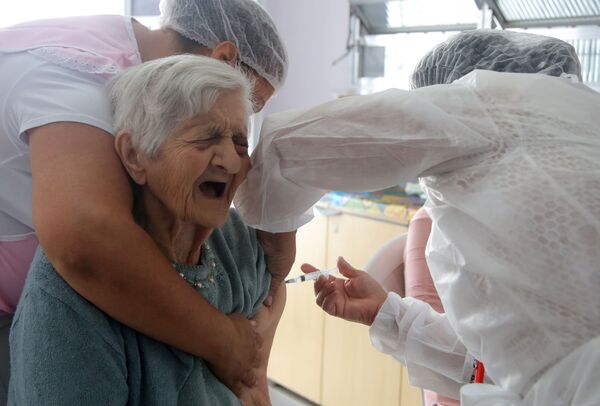 Funcionária da saúde aplica segunda dose da vacina CoronaVac a uma pessoa idosa na Residencial e Creche para Idosos Solar das Acácias perto de São Paulo, Brasil, 26 de fevereiro de 2021 - Sputnik Brasil