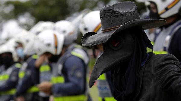 Manifestante usa máscara de pássaro preto, simbolizando a peste negra, em Brasília, 1º de março de 2021  - Sputnik Brasil