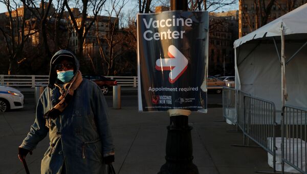 Mulher com máscara passa próximo a um centro de vacinação no Bronx, em Nova York, nos Estados Unidos - Sputnik Brasil