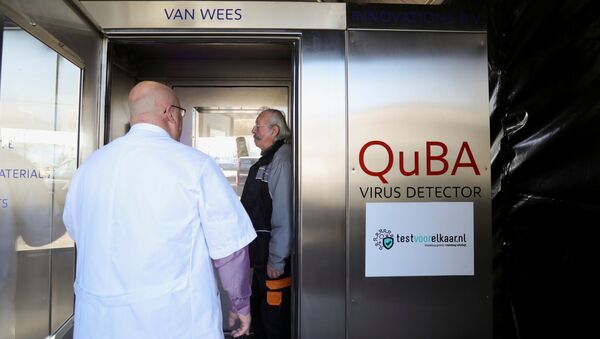 Peter van Wees explains John Moritz when to shout in the quick breath analyzer cabin that tests for the coronavirus disease (COVID-19) at a testing location in Amsterdam, Netherlands March 1, 2021. Picture taken March 1, 2021. - Sputnik Brasil