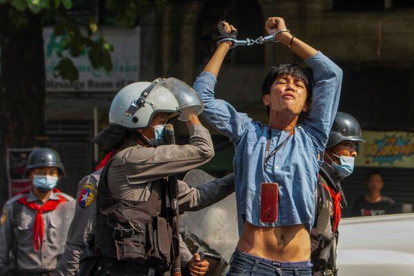 Manifestante detido por policiais durante protestos contra golpe militar em Myanmar, 27 de fevereiro de 2021 - Sputnik Brasil