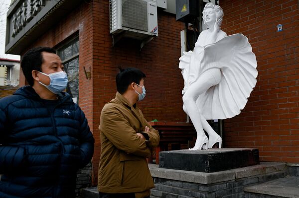 Transeuntes perto de estátua ao lado de uma loja em Pequim, China, 2 de março de 2021 - Sputnik Brasil