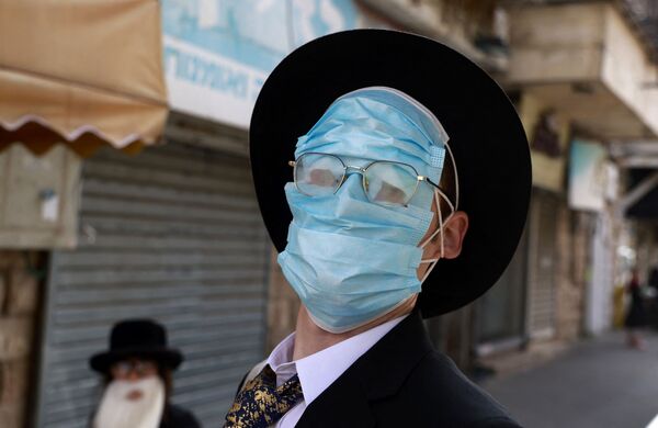 Homem usa várias máscaras durante celebrações de Purim, Jerusalém, 28 de fevereiro de 2021 - Sputnik Brasil