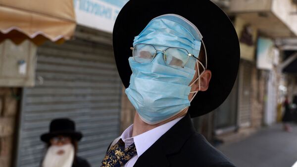 Homem usa várias máscaras durante celebrações de Purim, Jerusalém, 28 de fevereiro de 2021 - Sputnik Brasil