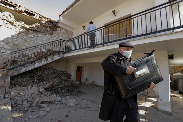 Homem levando televisão de sua casa destruída por terremoto na Grécia central, 3 de março de 2021 - Sputnik Brasil