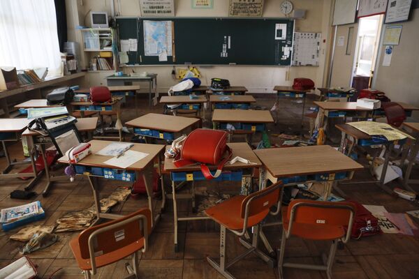 Sala de aula de escola primária abandonada cheia de mochilas escolares e outras coisas de alunos deixadas para trás durante evacuações após terremoto de 2011, em Futaba, prefeitura de Fukushima, Japão, 3 de dezembro de 2019 - Sputnik Brasil