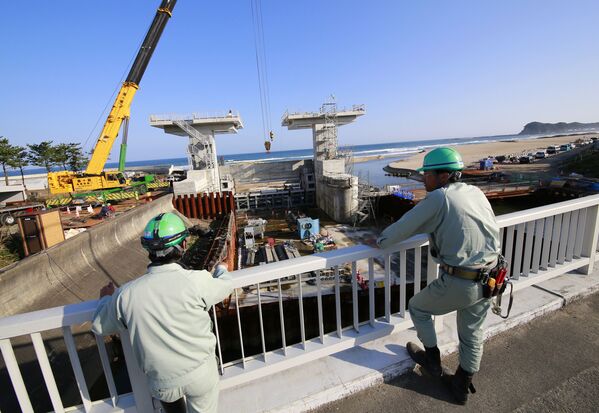 Trabalhadores olham para uma comporta em construção após alerta de tsunami ser emitido, em Iwaki, prefeitura de Fukushima, Japão, 22 de novembro de 2016 - Sputnik Brasil