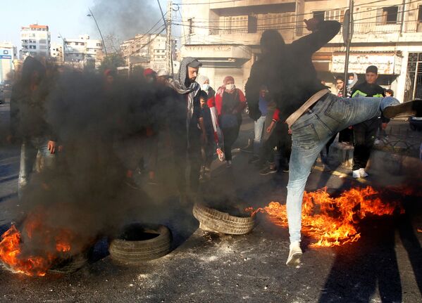 Manifestantes bloqueiam estrada com pneus incendiados durante uma ação de protesto contra a queda da libra libanesa em Sidon, Líbano
 - Sputnik Brasil