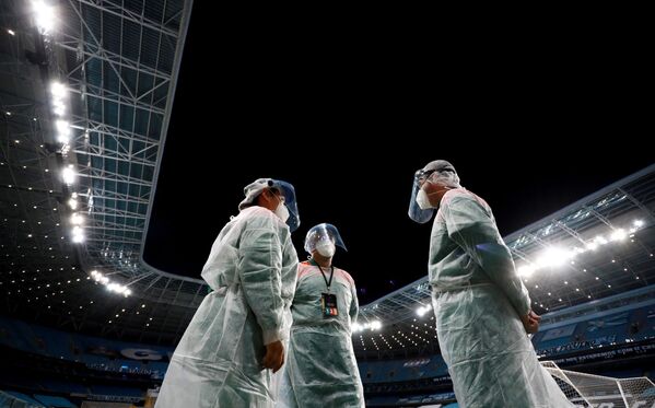 Funcionários da Arena do Grêmio em Porto Alegre vestindo trajes de proteção durante qualificação da Copa Libertadores, 11 de março de 2021 - Sputnik Brasil
