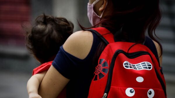 Criança é vista no colo da mãe em rua da cidade de São Paulo. - Sputnik Brasil