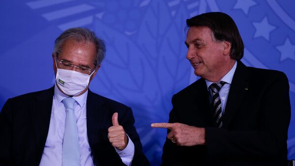 Em Brasília, o presidente brasileiro, Jair Bolsonaro (à direita) aponta na direção do ministro da Economia, Paulo Guedes (à esquerda), que gesticula. Foto de arquivo - Sputnik Brasil