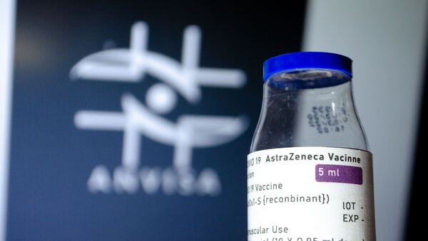 No Rio de Janeiro, um frasco com a vacina contra a COVID-19 da AstraZeneca/Oxford/ é exibida à frente do logo da Agência Nacional de Vigilância Sanitária (Anvisa), em 12 de março de 2021 - Sputnik Brasil