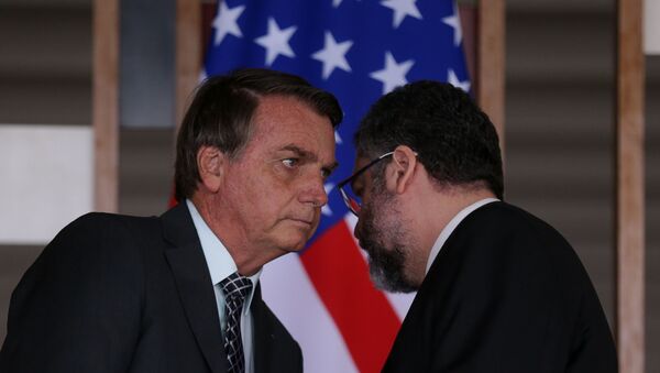 O presidente Jair Bolsonaro conversa com o ministro das Relações Exteriores, Ernesto Araújo, com a bandeira dos EUA ao fundo. - Sputnik Brasil