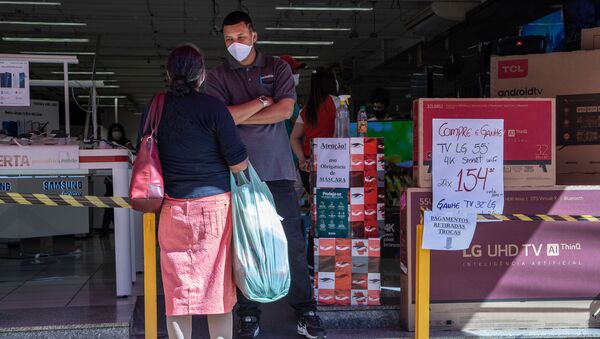 Funcionário com máscara de proteção e álcool em gel em loja de eletrônicos em Marília, interior de São Paulo. - Sputnik Brasil