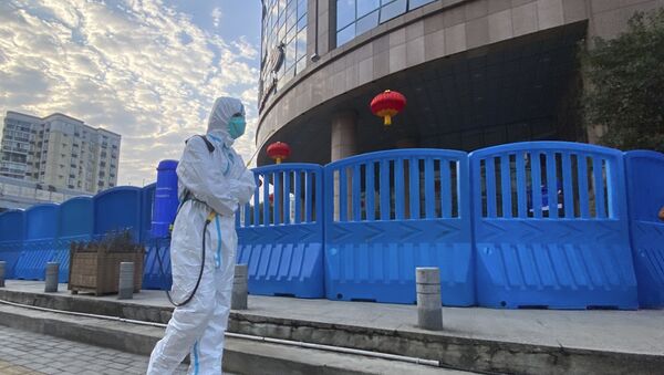 Trabalhador desinfeta do lado de fora do Centro Hospitalar de Wuhan, na China - Sputnik Brasil