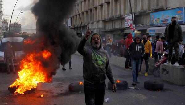 Manifestante gesticula durante um protesto contra a queda da libra libanesa e as crescentes dificuldades econômicas, em Sidon, Líbano, 8 de março de 2021 - Sputnik Brasil